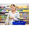 Pretty young woman buying groceries in a supermarket/mall/grocery store (color toned image; shallow DOF)