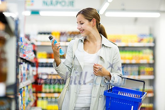 Beautiful young woman shopping in a grocery store/supermarket (color toned image) Beautiful young woman shopping in a grocery store/supermarket (color toned image)