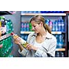 Beautiful young woman shopping in a grocery store/supermarket (color toned image)