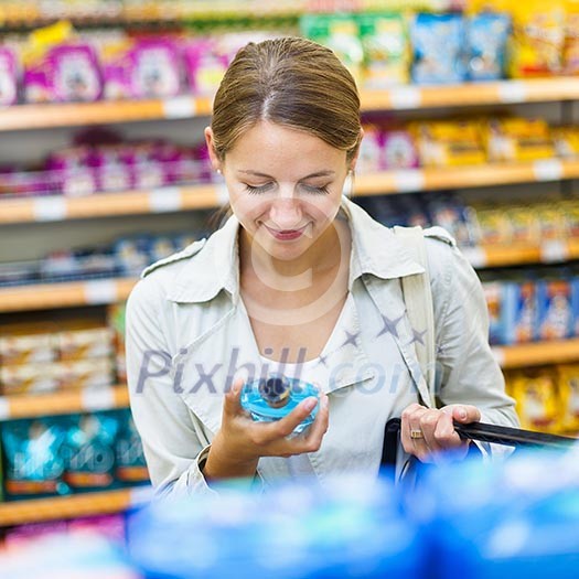Beautiful young woman shopping in a grocery store/supermarket (color toned image) Beautiful young woman shopping in a grocery store/supermarket (color toned image)