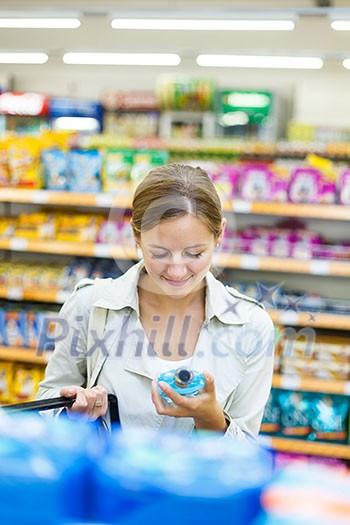 Beautiful young woman shopping in a grocery store/supermarket (color toned image) Beautiful young woman shopping in a grocery store/supermarket (color toned image)