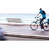 Great way to get around in a city -Motion blurred cyclist going fast on a city bike lane, by the sea shore