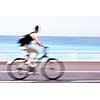 Great way to get around in a city -Motion blurred cyclist going fast on a city bike lane, by the sea shore