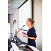 Pretty, young business woman giving a presentation in a conference/meeting setting (shallow DOF; color toned image)