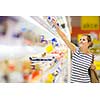 Beautiful young woman shopping for diary products at a grocery store/supermarket (color toned image)