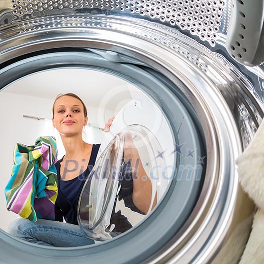 Housework: young woman doing laundry (shallow DOF; color toned image) Housework: young woman doing laundry (shallow DOF; color toned image)