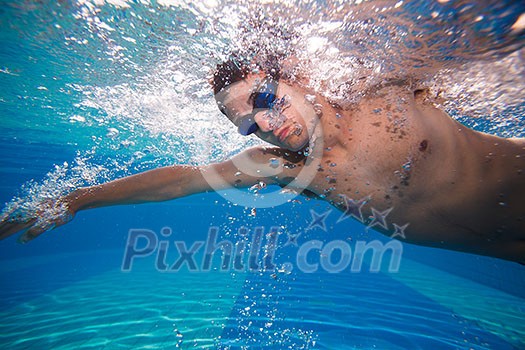 Young man swimming the front crawl in a pool - underwater shot (color toned image) Young man swimming the front crawl in a pool - underwater shot (color toned image)