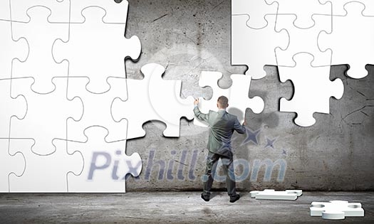 Image of businessman compiling macro white puzzle. Building business Image of businessman compiling macro white puzzle. Building business