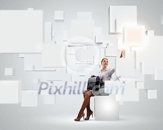 Image of elegant businesswoman sitting on white cube touching media button Image of elegant businesswoman sitting on white cube touching media button