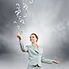 Image of young attractive businesswoman holding question marks in hand