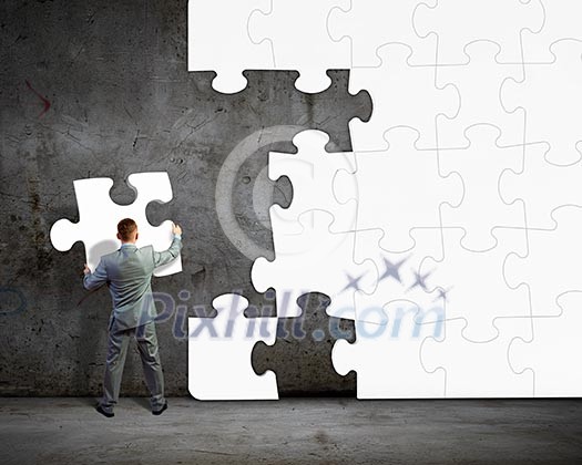 Image of businessman compiling macro white puzzle. Building business Image of businessman compiling macro white puzzle. Building business