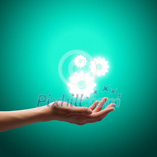 Close up image of human hand holding gears Close up image of human hand holding gears