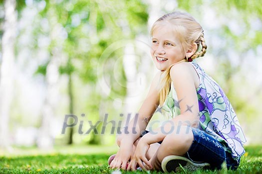 Image of little cute girl sitting on grass in park Image of little cute girl sitting on grass in park