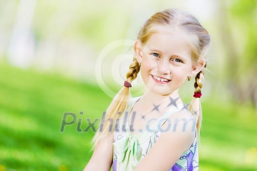 Image of little cute girl sitting on grass in park Image of little cute girl sitting on grass in park
