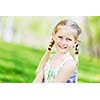 Image of little cute girl sitting on grass in park