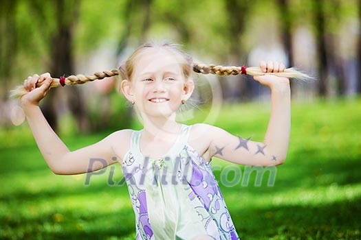 Image of little cute girl sitting on grass in park Image of little cute girl sitting on grass in park