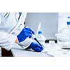 Hands of a researcher carrying out scientific research experiment in a lab (shallow DOF; color toned image)