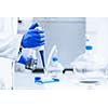 Hands of a researcher carrying out scientific research experiment in a lab (shallow DOF; color toned image)