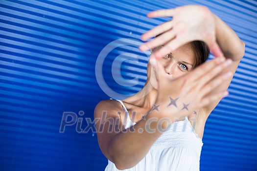 Pretty, young woman making a photo composing/shooting gesture with her hands Pretty, young woman making a photo composing/shooting gesture with her hands