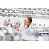 Pretty, young woman choosing a the right pot for her cooking in a modern home furnishings store (color toned image; shallow DOF)
