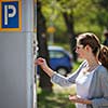 Young woman paying for parking