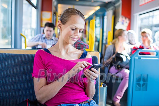 Pretty, young woman on a streetcar/tramway, during her commute to work/school (color toned image; shallow DOF) Pretty, young woman on a streetcar/tramway, during her commute to work/school (color toned image; shallow DOF)