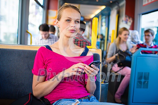 Pretty, young woman on a streetcar/tramway, during her commute to work/school (color toned image; shallow DOF) Pretty, young woman on a streetcar/tramway, during her commute to work/school (color toned image; shallow DOF)