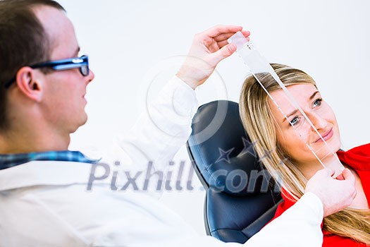 Optometry concept - pretty young woman having her eyes examined by an eye doctor (color toned image; shallow DOF) Optometry concept - pretty young woman having her eyes examined by an eye doctor (color toned image; shallow DOF)