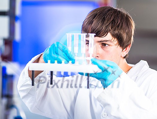 Young male researcher carrying out scientific research in a lab (shallow DOF; color toned image) Young male researcher carrying out scientific research in a lab (shallow DOF; color toned image)