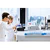 Two young researchers carrying out experiments in a lab (shallow DOF; color toned image)
