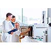 Team of researchers carrying out experiments in a lab (shallow DOF; color toned image)