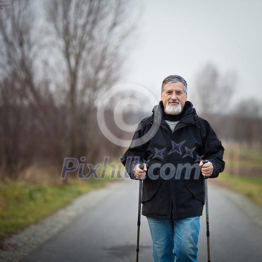 Senior man nordic walking, enjoying the outdoors, the fresh air, getting the necessary exercise Senior man nordic walking, enjoying the outdoors, the fresh air, getting the necessary exercise