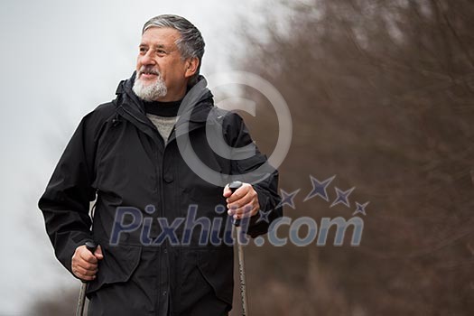 Senior man nordic walking, enjoying the outdoors, the fresh air, getting the necessary exercise Senior man nordic walking, enjoying the outdoors, the fresh air, getting the necessary exercise