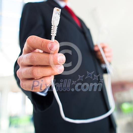 Young businessman holding an ethernet cable - stressing the importance of fast and reliable internet connection for a business (color toned image; shallow DOF) Young businessman holding an ethernet cable - stressing the importance of fast and reliable internet connection for a business (color toned image; shallow DOF)
