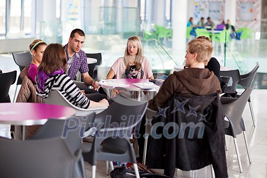 Group of college/university students during a brake between classes - chatting, comparing notes, having fun (shallow DOF; color toned image) Group of college/university students during a brake between classes - chatting, comparing notes, having fun (shallow DOF; color toned image)