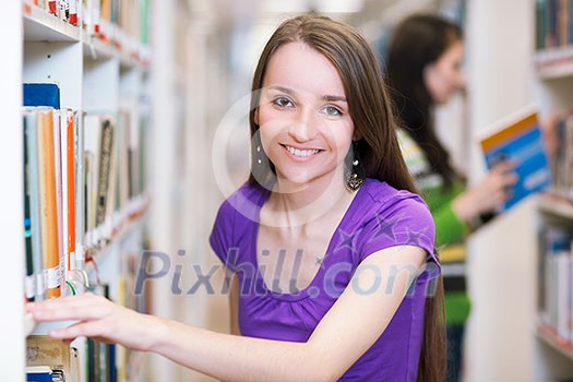 In the library - pretty, female student searching for books in a high school/university library (color toned image) In the library - pretty, female student searching for books in a high school/university library (color toned image)