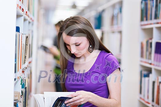In the library - pretty, female student searching for books in a high school/university library (color toned image) In the library - pretty, female student searching for books in a high school/university library (color toned image)