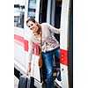 Pretty young woman boarding a train (color toned image)