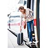 Pretty young woman boarding a train (color toned image)