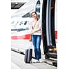 Pretty young woman boarding a train (color toned image)