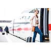 Pretty young woman boarding a train (color toned image)