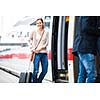 Pretty young woman boarding a train (color toned image)