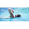 Young man swimming the front crawl in a pool