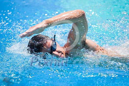 Young man swimming the front crawl in a pool Young man swimming the front crawl in a pool