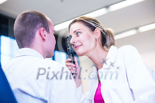 Optometry concept - handsome young man having his eyes examined by an eye doctor (color toned image; shallow DOF) Optometry concept - handsome young man having his eyes examined by an eye doctor (color toned image; shallow DOF)