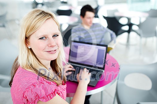 Two college students having fun studying together, using a laptop computer on campus, between classes (shallow DOF, color toned image) Two college students having fun studying together, using a laptop computer on campus, between classes (shallow DOF, color toned image)