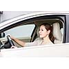 Pretty young woman driving her new car