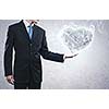 Businessman holding stone in shape of heart in palm