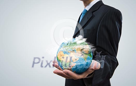 Close up of businessman holding Earth planet in palm. Elements of this image are furnished by NASA Close up of businessman holding Earth planet in palm. Elements of this image are furnished by NASA