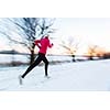 Young woman running outdoors on a cold winter day (motion blurred image)